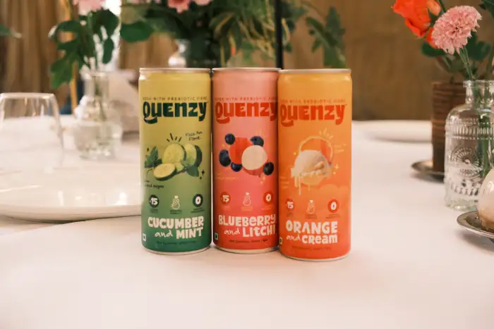Three drink cans set on a dinner table at an event